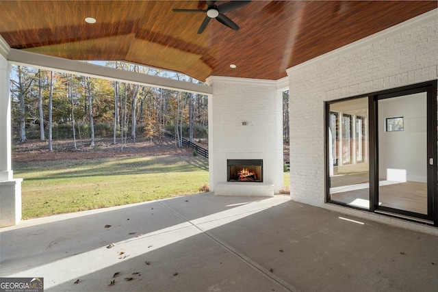 view of patio featuring an outdoor brick fireplace and ceiling fan