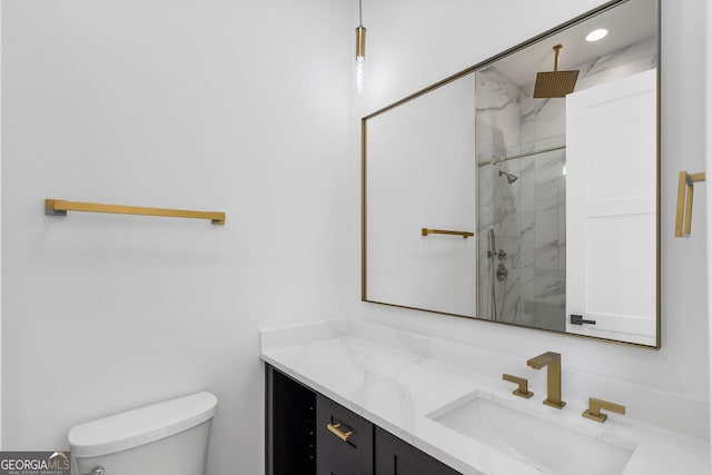 bathroom with vanity, toilet, and a shower with shower door