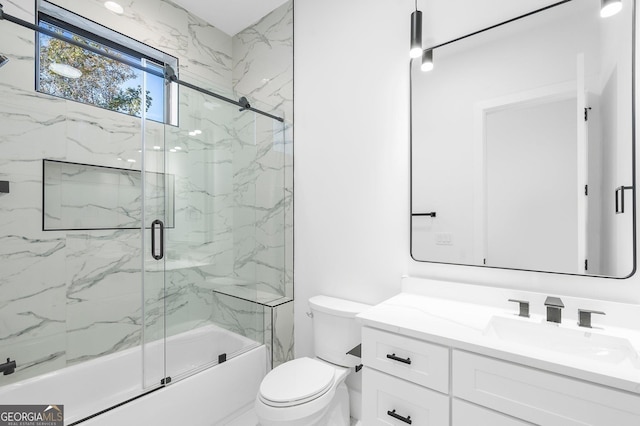 full bathroom with vanity, bath / shower combo with glass door, and toilet