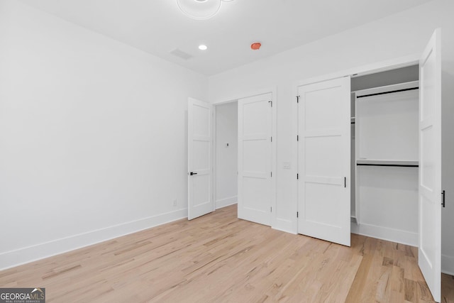 unfurnished bedroom featuring light hardwood / wood-style floors and a closet