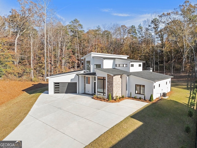 modern home with a garage, central AC, and a front yard