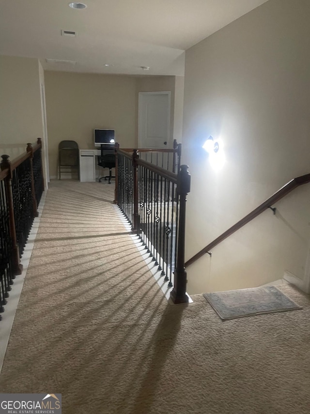 staircase featuring carpet