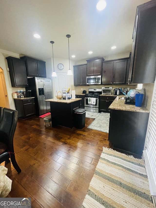 kitchen with dark wood-style floors, decorative light fixtures, a center island, stainless steel appliances, and recessed lighting