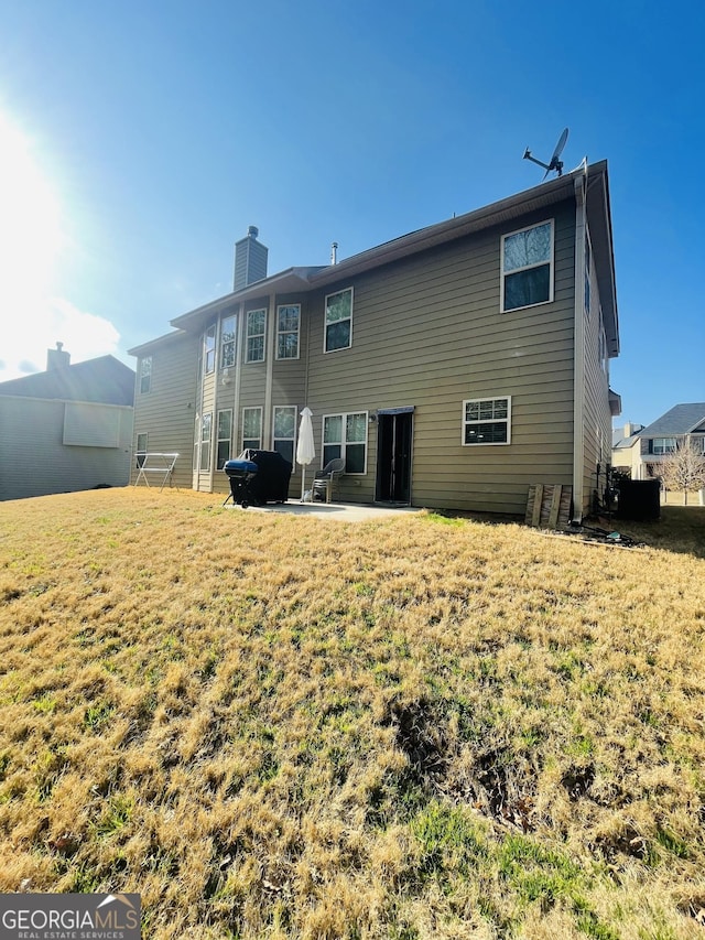 rear view of property featuring a patio area and a lawn