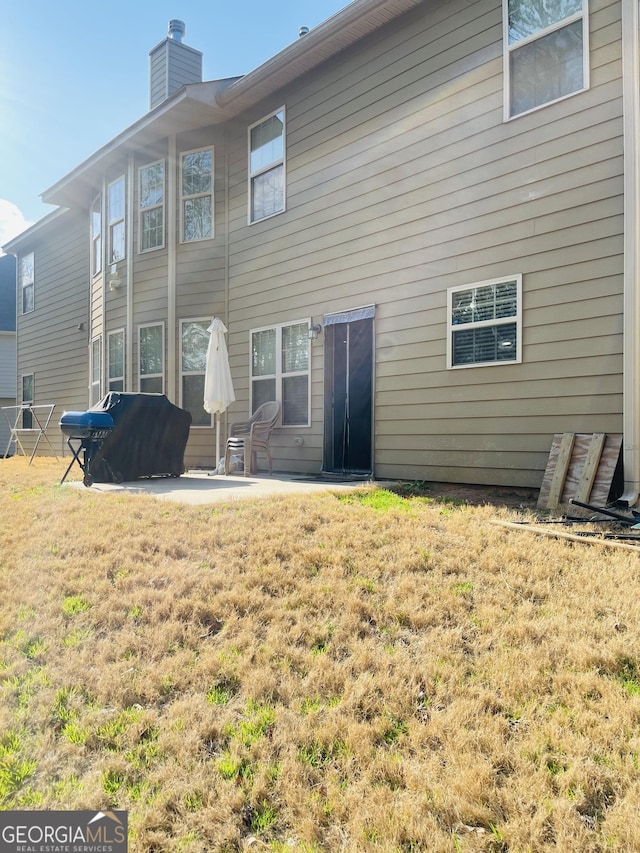 rear view of property with a yard and a patio