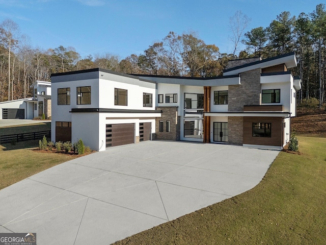 contemporary home featuring a garage and a front lawn