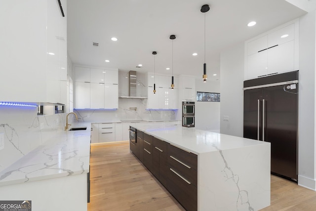 kitchen with white cabinetry, decorative light fixtures, paneled fridge, and a kitchen island