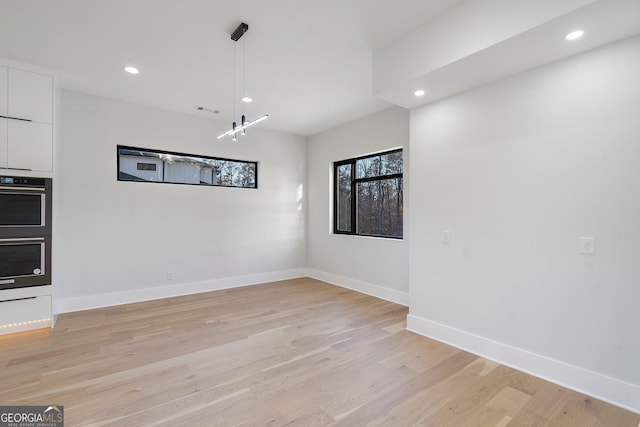 unfurnished dining area with light wood-type flooring