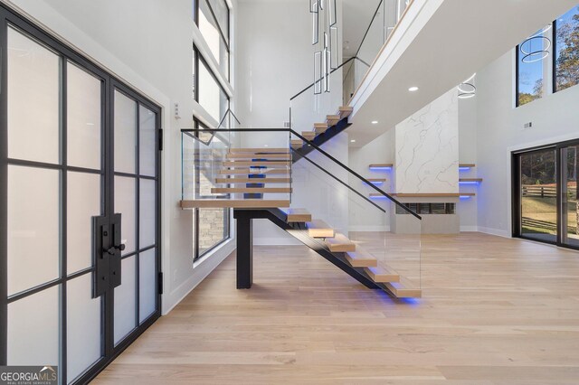 entryway featuring light hardwood / wood-style flooring, french doors, and a high ceiling