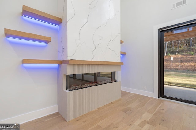 interior space featuring a multi sided fireplace and light wood-type flooring