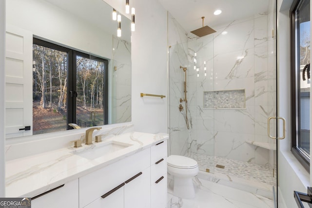 bathroom featuring vanity, a shower with door, and toilet