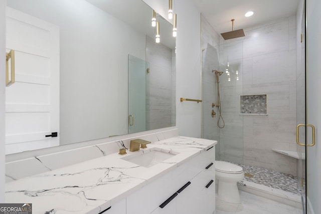 bathroom featuring vanity, a shower with door, and toilet