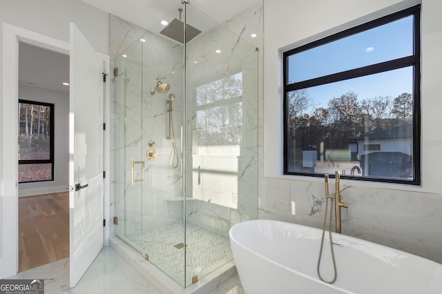 bathroom featuring separate shower and tub and tile walls