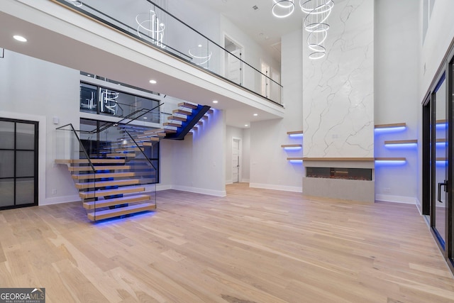 interior space featuring hardwood / wood-style flooring, a high ceiling, and a fireplace