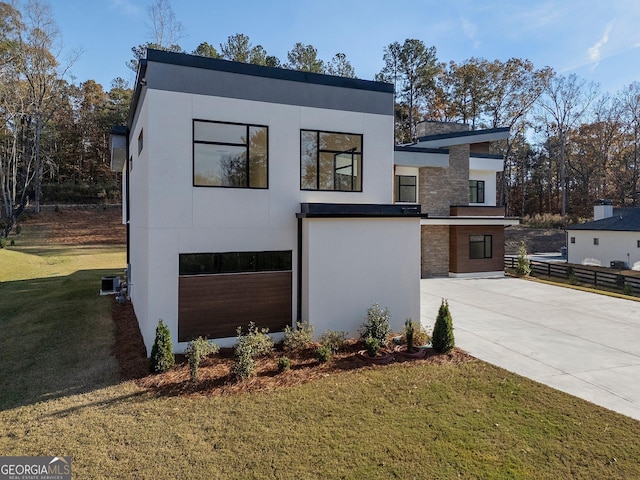 contemporary house featuring a garage and a front lawn