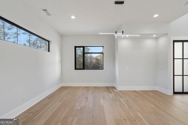 empty room with light hardwood / wood-style floors and a barn door