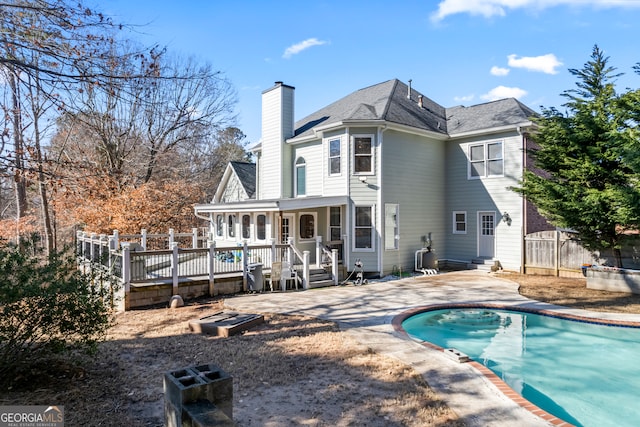 back of house featuring a pool side deck and a patio area