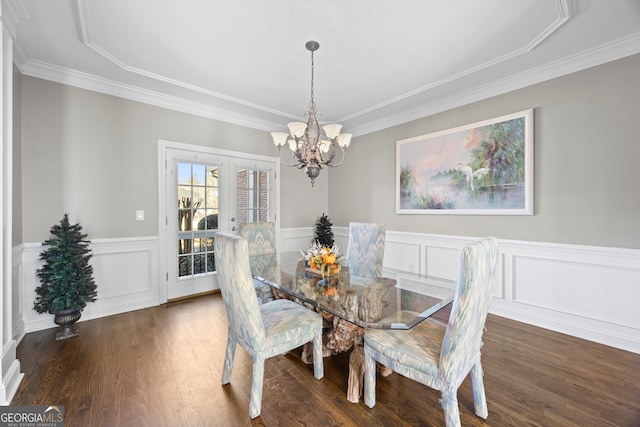 dining space with crown molding, dark wood-type flooring, and a chandelier