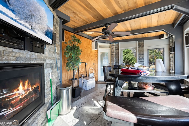 interior space featuring beam ceiling, wooden ceiling, an outdoor stone fireplace, and hardwood / wood-style flooring