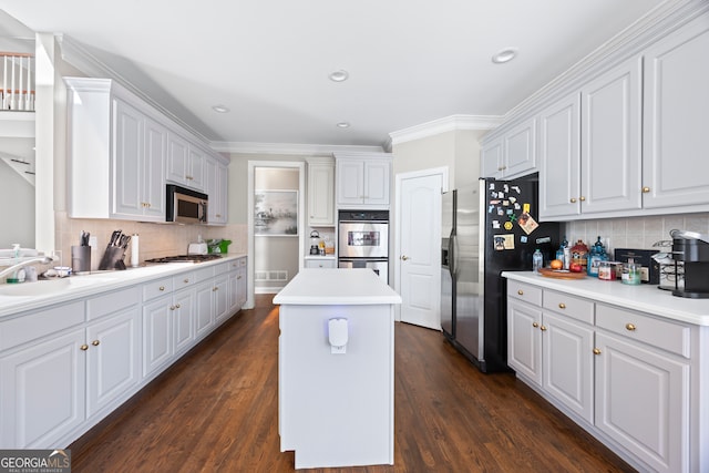 kitchen featuring dark hardwood / wood-style floors, sink, white cabinets, a center island, and stainless steel appliances