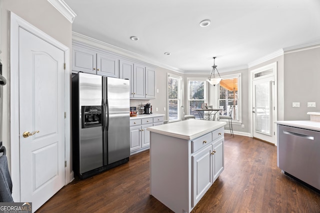 kitchen with dark hardwood / wood-style floors, hanging light fixtures, ornamental molding, a center island, and stainless steel appliances