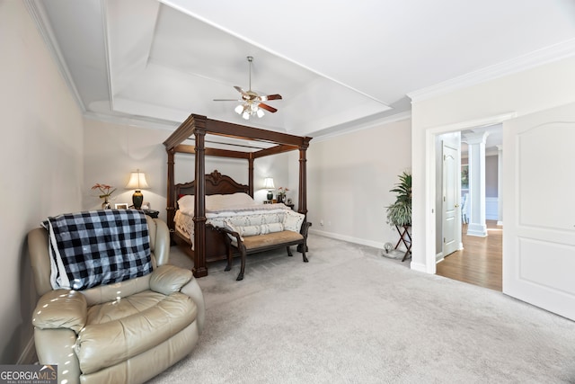 bedroom with a raised ceiling, crown molding, light carpet, and decorative columns