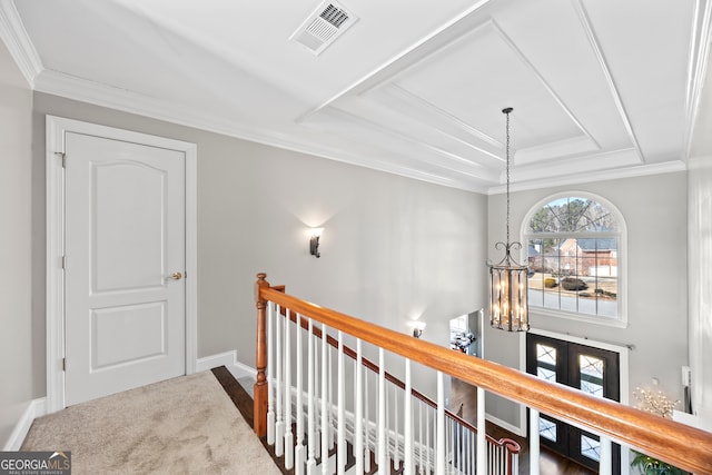 hallway featuring an inviting chandelier, a tray ceiling, ornamental molding, and french doors