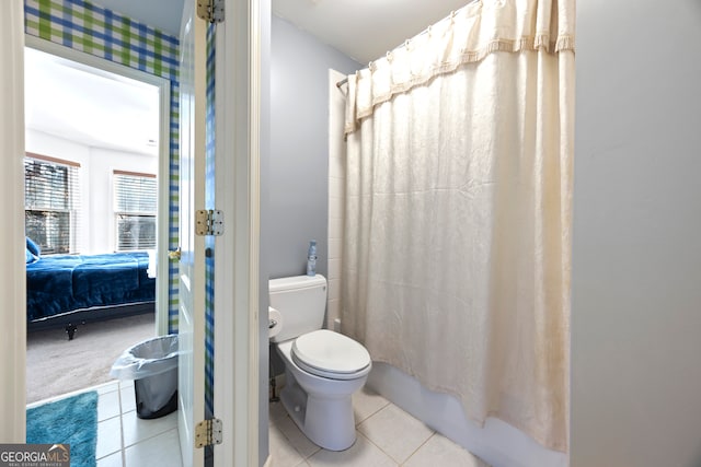 bathroom featuring tile patterned flooring, shower / bath combo, and toilet