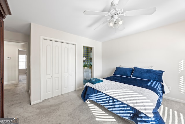 carpeted bedroom with ceiling fan and a closet