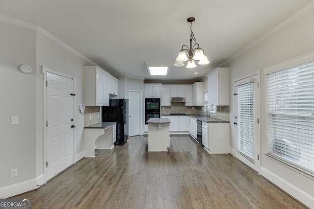 kitchen with sink, a center island, hardwood / wood-style flooring, pendant lighting, and white cabinets