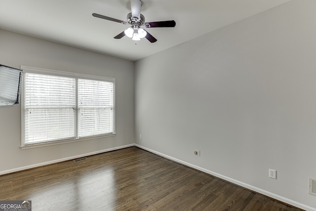 empty room featuring dark wood-type flooring and ceiling fan