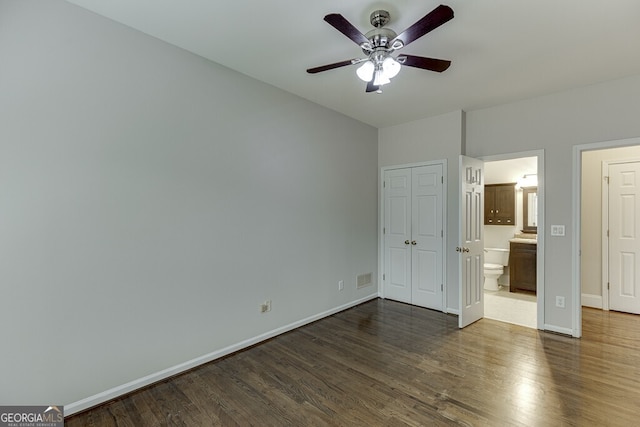 unfurnished bedroom with ceiling fan, dark hardwood / wood-style floors, and ensuite bath