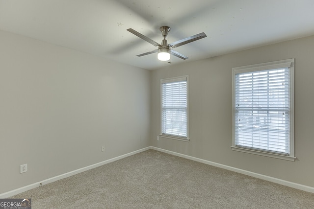 carpeted empty room featuring ceiling fan