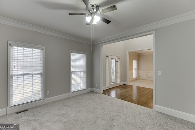 empty room featuring crown molding, carpet, and ceiling fan