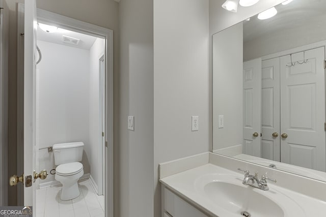 bathroom featuring vanity, tile patterned floors, and toilet