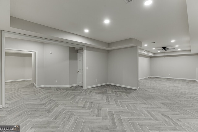 basement featuring ceiling fan and light parquet floors