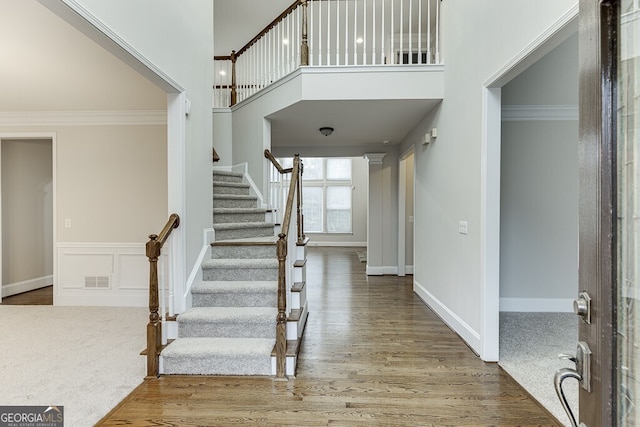 foyer featuring crown molding, a high ceiling, and hardwood / wood-style flooring