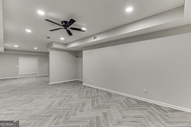 basement with ceiling fan and light parquet floors