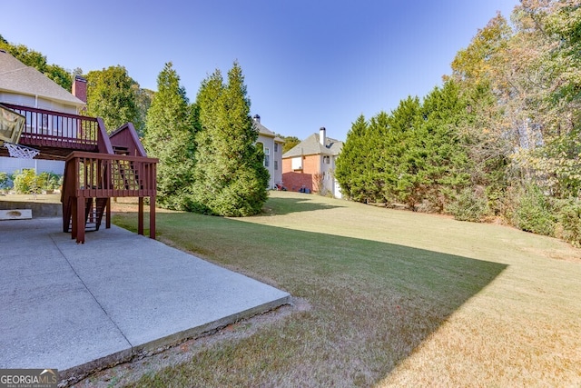 view of yard featuring a wooden deck and a patio