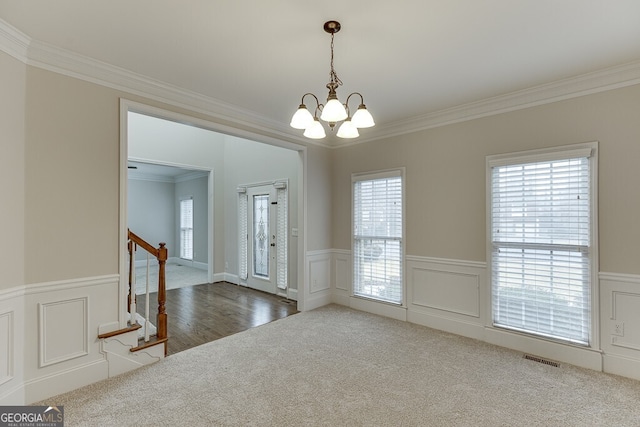 interior space featuring a notable chandelier, crown molding, and carpet flooring