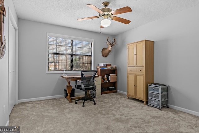 carpeted office featuring ceiling fan and a textured ceiling