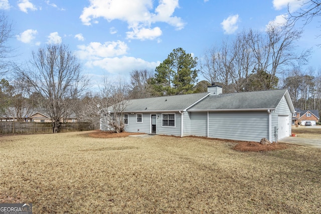 back of house with a garage and a yard