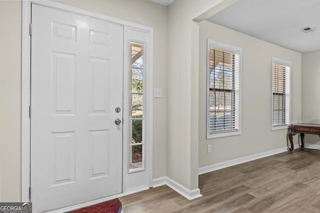 foyer featuring hardwood / wood-style flooring and a textured ceiling