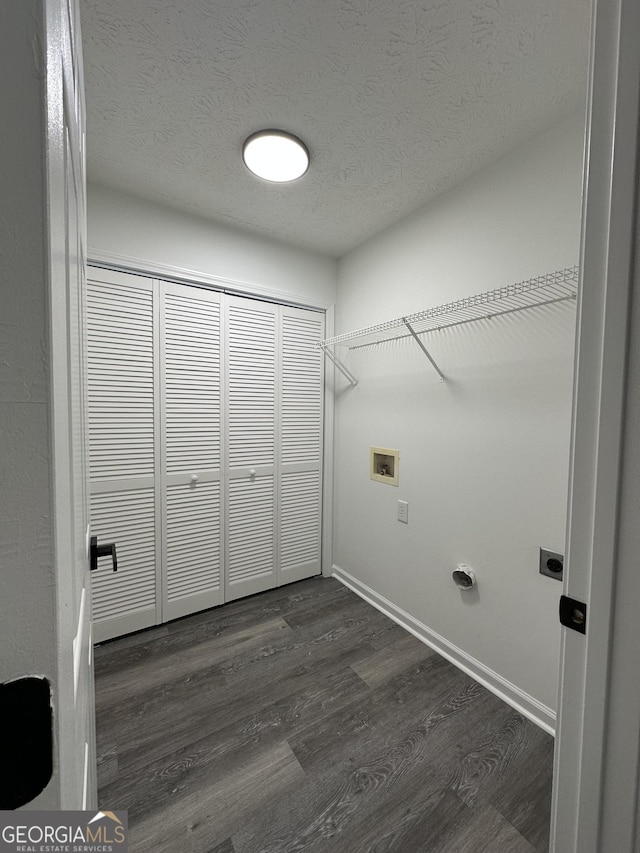 laundry room featuring electric dryer hookup, dark wood-type flooring, washer hookup, and a textured ceiling