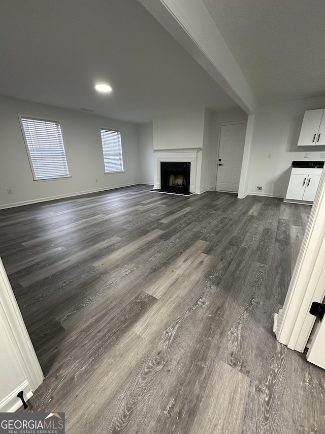 unfurnished living room with dark hardwood / wood-style flooring