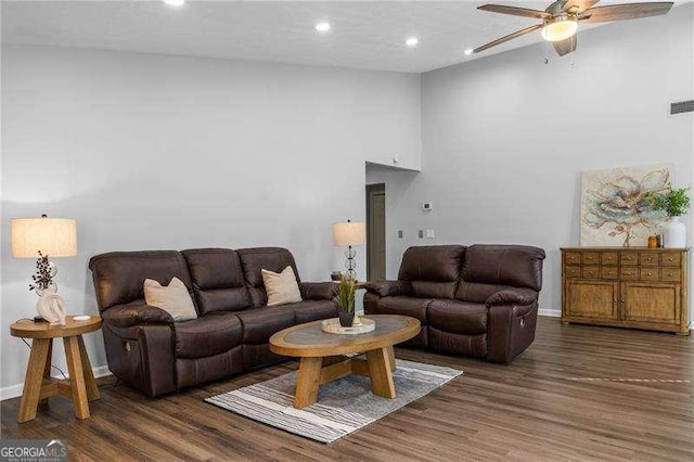 living room featuring ceiling fan, dark hardwood / wood-style flooring, and a high ceiling