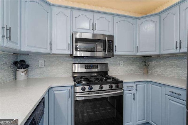 kitchen with tasteful backsplash, appliances with stainless steel finishes, and blue cabinets