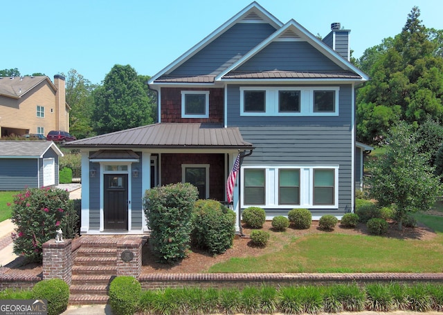 10 Plum Blossom Ln, Hampton, GA 30228 - view of front of home featuring a chimney, metal roof, and a front lawn