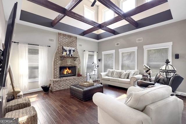 living room with a high ceiling, coffered ceiling, dark wood-type flooring, and a fireplace