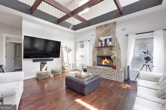 living room featuring a fireplace, dark wood-type flooring, and a high ceiling